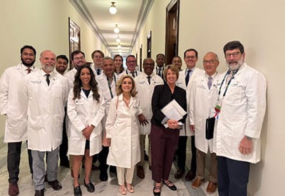Group of medical center radiologists and evms physicians in white coats standing in a hallway during the acr annual meeting.