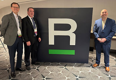 Three medical center radiologists physicians standing beside a large r-sign at the acr annual meeting.