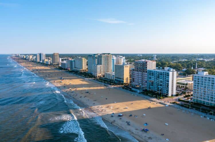 Hampton-roads-virginia-beach Aerial view of the virginia beach oceanfront with shoreline, hotels, and surrounding cityscape on a clear day.