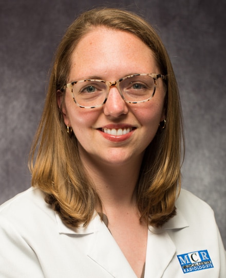 Amy farkas, md. Female healthcare professional in a white coat smiling against a backdrop.