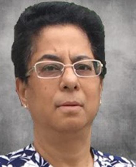 Anita kelekar, md, a radiologist, smiling against a grey backdrop.