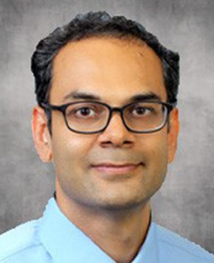 Bimal patel, do smiling in front of a grey backdrop.