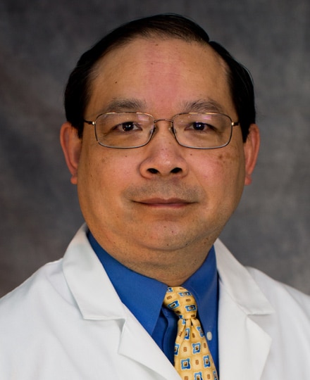 Chan nguyen, md smiling in front of a professional backdrop.