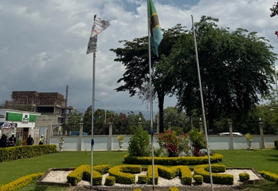Front entrance of kilimanjaro christian medical centre (kcmc) in tanzania with landscaped grounds and flagpoles during rad-aid radiology outreach.