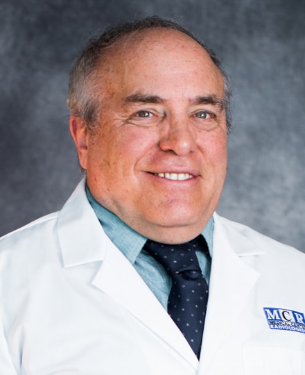 John bisese, ph. Professional headshot of a male radiologist wearing a white mcr lab coat and tie.