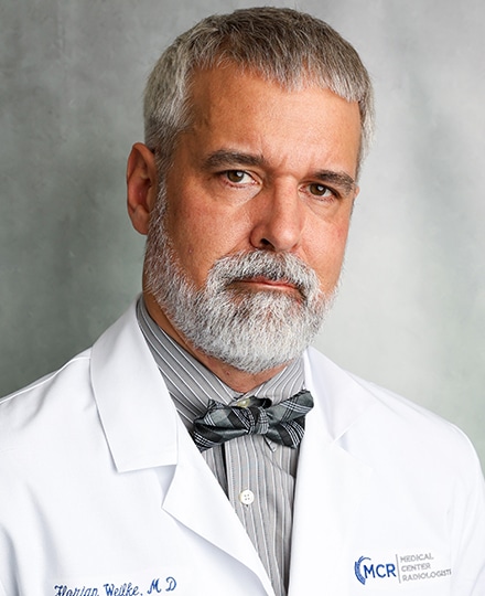 Florian weilke, md standing against a professional gray background.