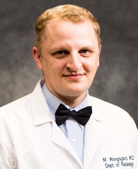 Mitchell wangsgard, md smiling against a grey background.