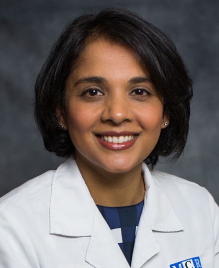 Prasanti vachhani, md smiling against a grey professional background.