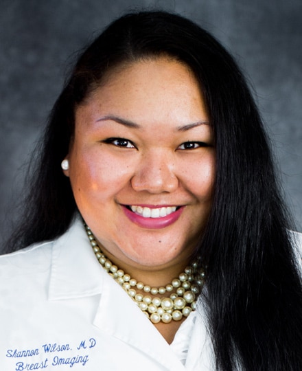 Shannon wilson, md smiling against a grey backdrop in a professional headshot.