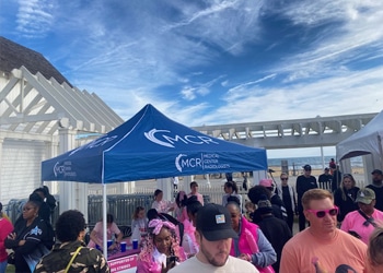 Mcr tent and volunteers at the making strides against breast cancer walk at the virginia beach oceanfront.