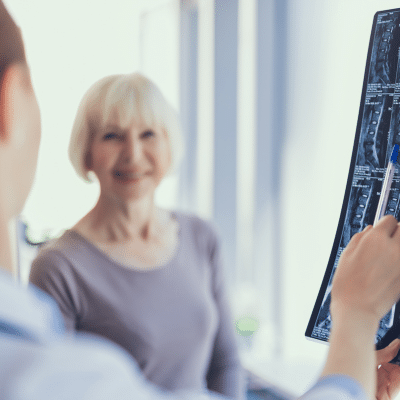 Older woman talking to a specialist at medical center radiologists, representing benefits of radiology over traditional surgery