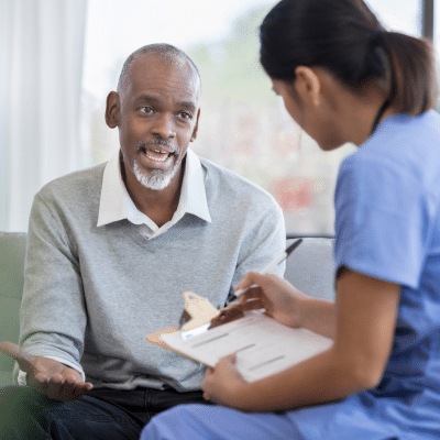Patient discussing with healthcare professional, representing preparing for an embolization procedure